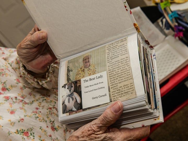 Gerry Cornell holding an album documenting the Memory Bears she created for hospice families